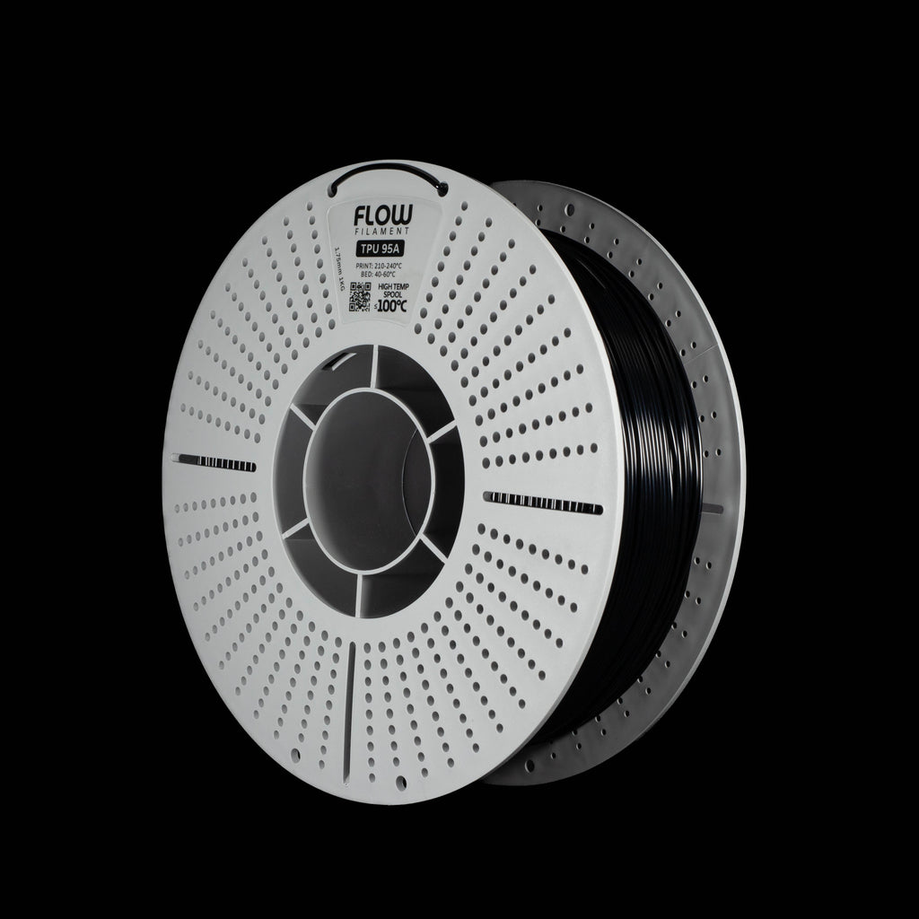 A spool of black 3D printer filament in black colour on a solid black background. The spool has a white outer rim with a circular vented pattern, with the brand name 'FLOW' printed on the spool.