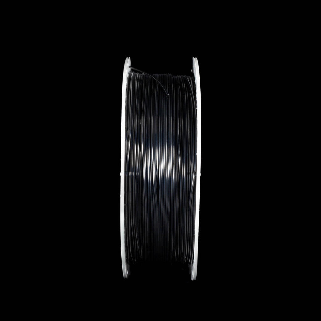 A spool of black 3D printer filament in black colour on a solid black background. 