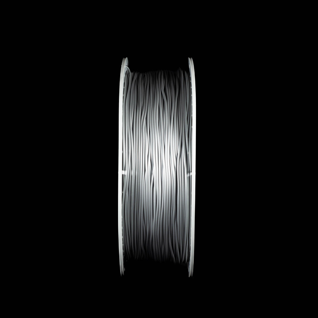 A spool of metallic silver 3D printing filament, shown vertically against a solid black background.