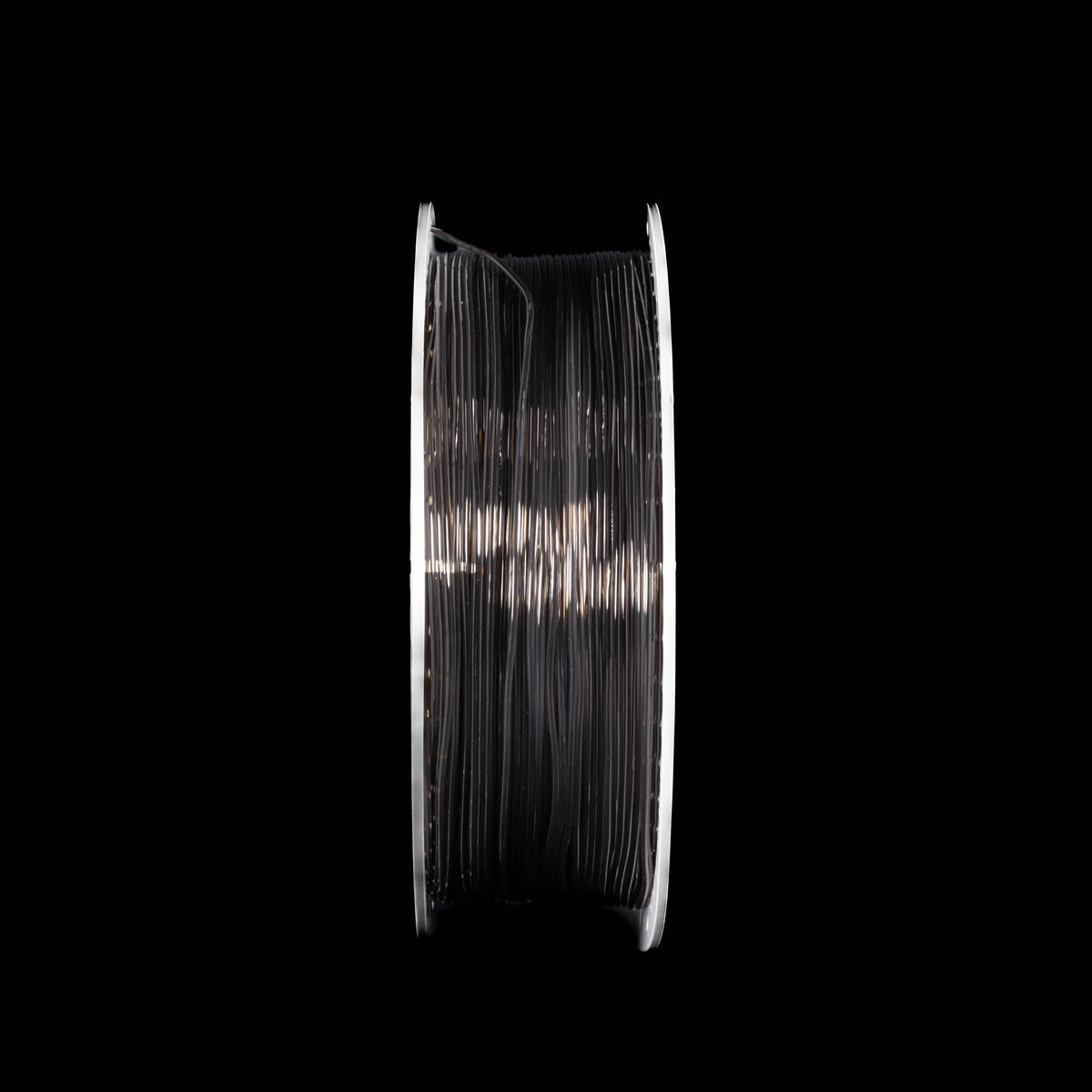 A spool of translucent grey 3D printing filament centered against a solid black background.
