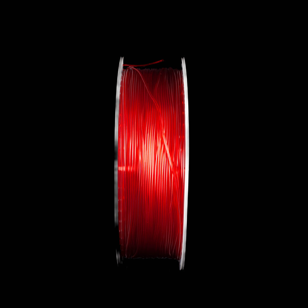A spool of translucent red 3D printing filament, shown vertically against a solid black background.
