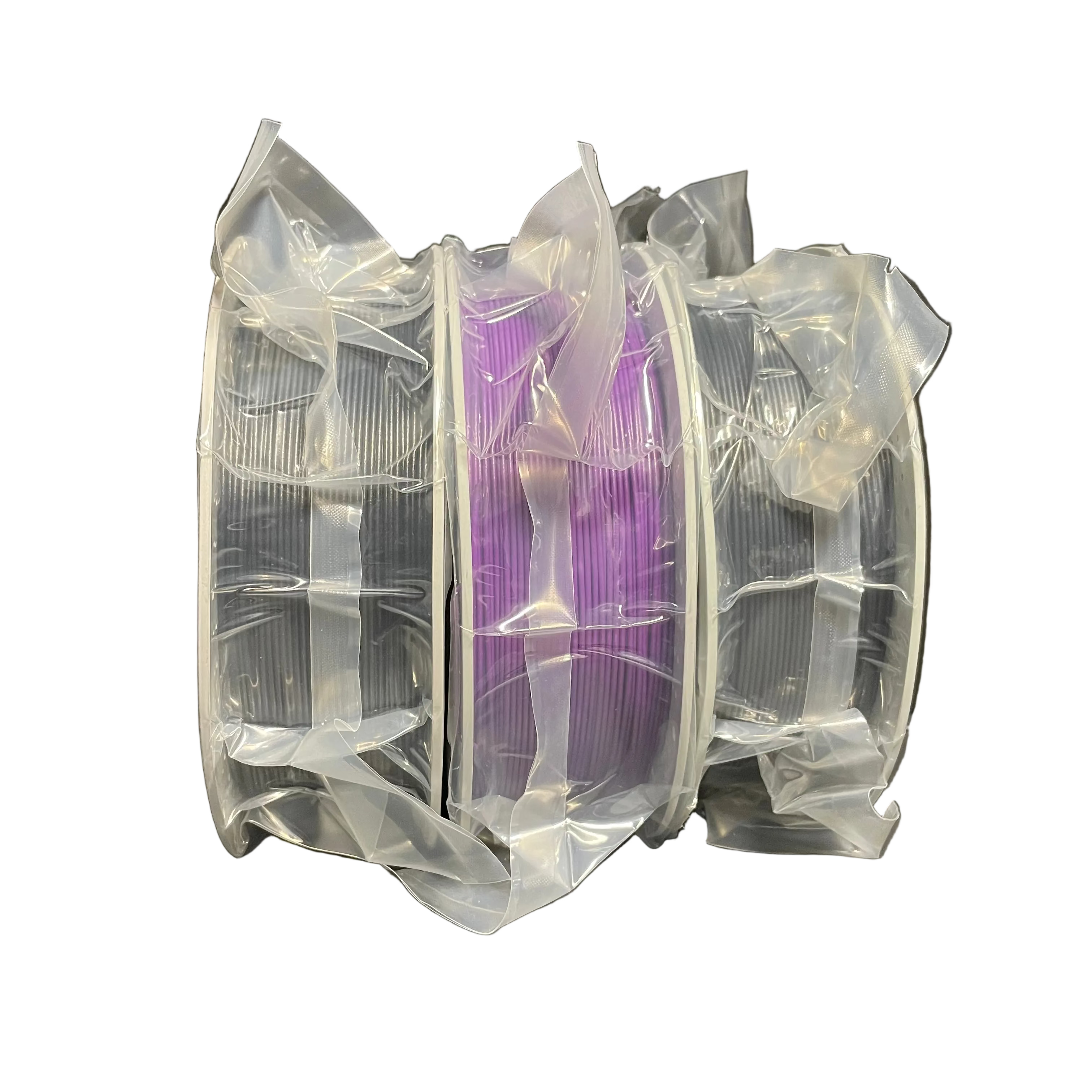 Three spools of 3D printing filament wrapped in clear plastic, with the center spool showing purple filament.